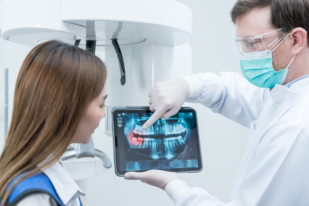 Caucasian,Male,Dentist,Hold,Digital,Tablet,And,Explaining,Tooth,Problem.